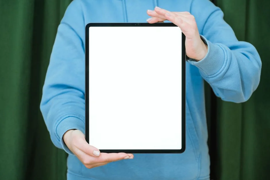 services-03 Poslovni stručnjak koristi tablet i laptop uz topli napitak, usmjeren na pregled digitalnog sadržaja.